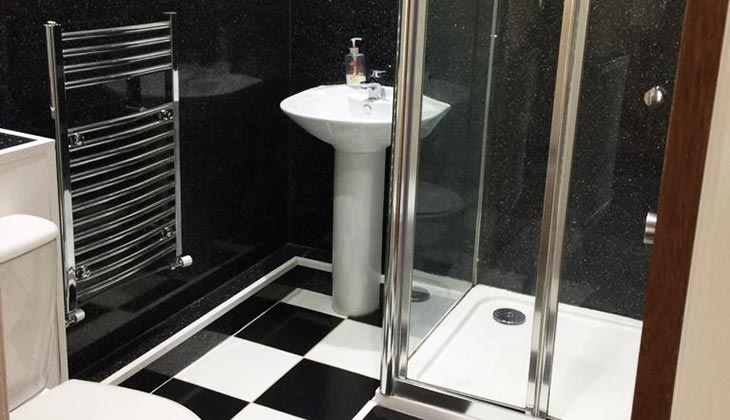 bathroom sink and shower with metal radiator